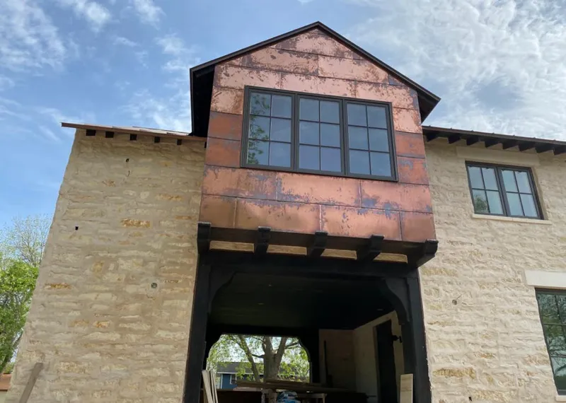 Copper metal panel facade on a stone building for Roof Repair in Evanston