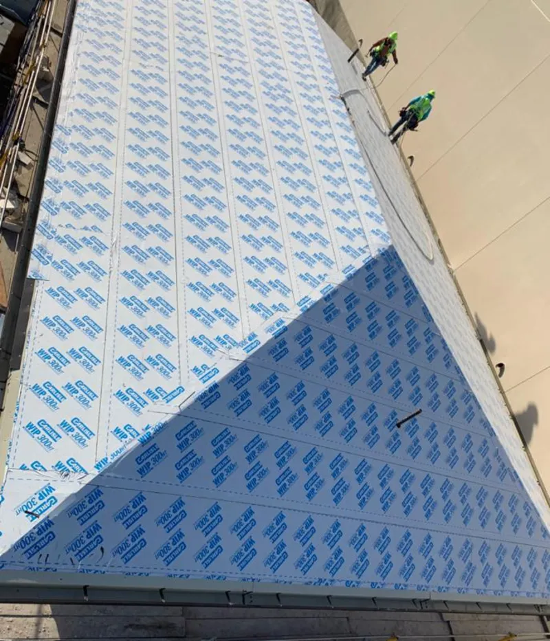 Professional roofers installing underlayment on a metal roof in Evanston